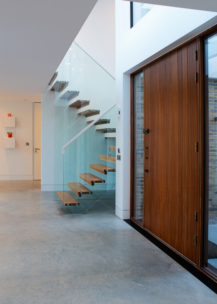 Feature entrance door, showing wood stairs with full glass balustrading to the first floor area