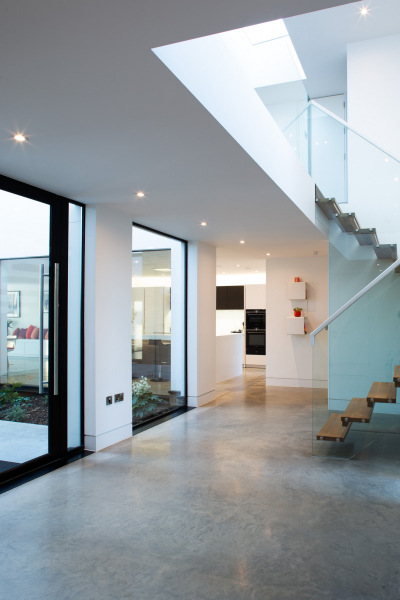 Bespoke hallway showing entrance to kitchen and wood/glass stairs to upper floor