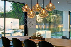 Dining table with bespoke lighting and great views out of large windows into the rear garden area