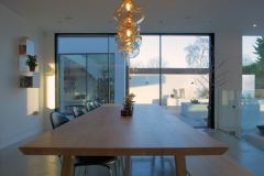 Large wooden breakfast table with bespoke pendant lights overhead