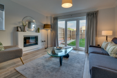 Living Area, with sofa & single seat, glass coffee table, fireplace with views out to rear garden