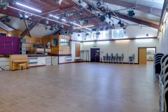 Main hall at Woodside hall, showing piano, open space, overhead theatre lighting